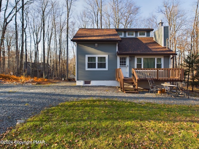 view of front of house with a deck and a front yard