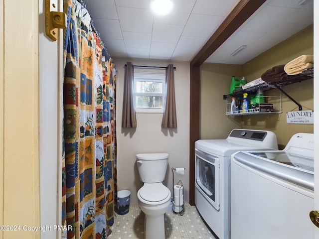 bathroom with separate washer and dryer and toilet