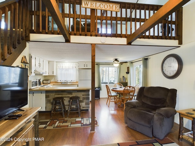 living room featuring sink, dark wood-type flooring, and ceiling fan