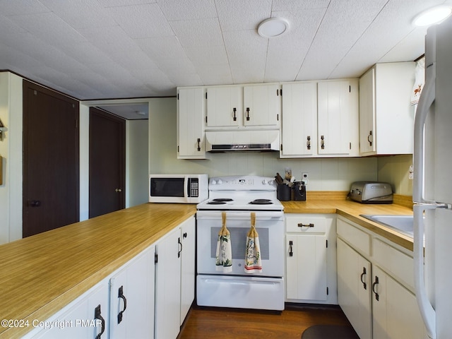 kitchen featuring dark wood-type flooring, white appliances, sink, and white cabinets