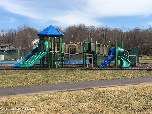 view of play area with a yard and tennis court