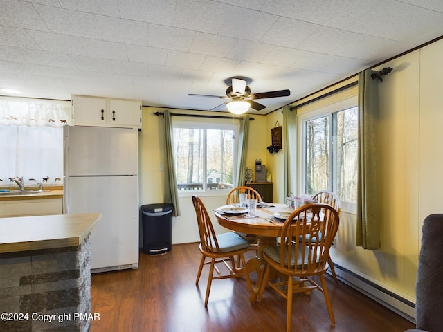 dining room with a baseboard radiator, dark hardwood / wood-style floors, sink, and ceiling fan