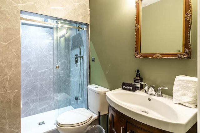 full bathroom featuring toilet, a stall shower, and vanity