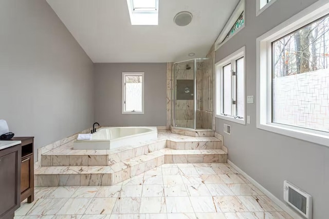 bathroom featuring visible vents, a shower stall, baseboards, a skylight, and a bath