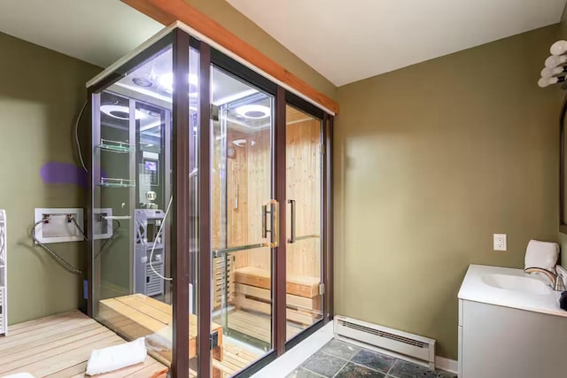 bathroom with a baseboard heating unit, baseboards, and vanity