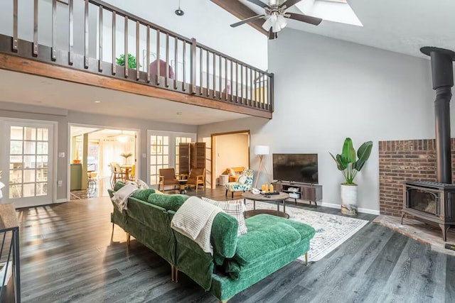 living room with wood finished floors, ceiling fan, and a wood stove