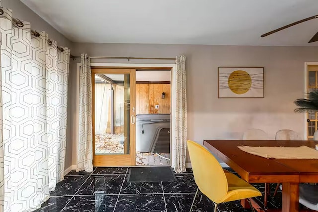 dining area with a ceiling fan and marble finish floor