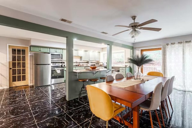 dining space featuring visible vents, marble finish floor, and a ceiling fan