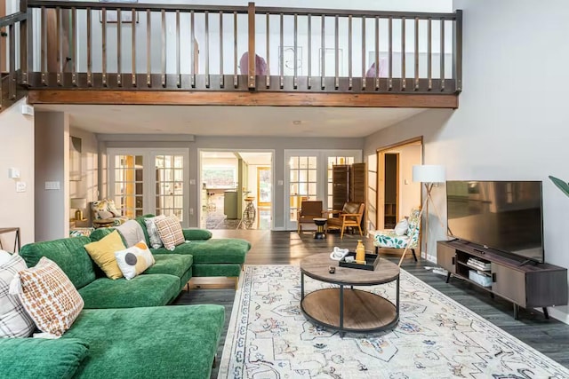 living room featuring wood finished floors, a high ceiling, and a healthy amount of sunlight