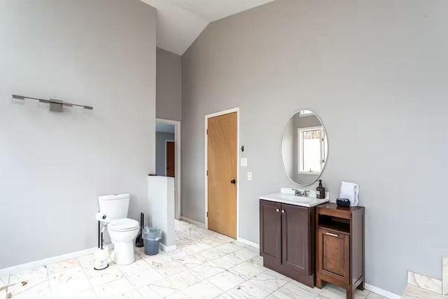 bathroom with vanity, toilet, baseboards, and marble finish floor