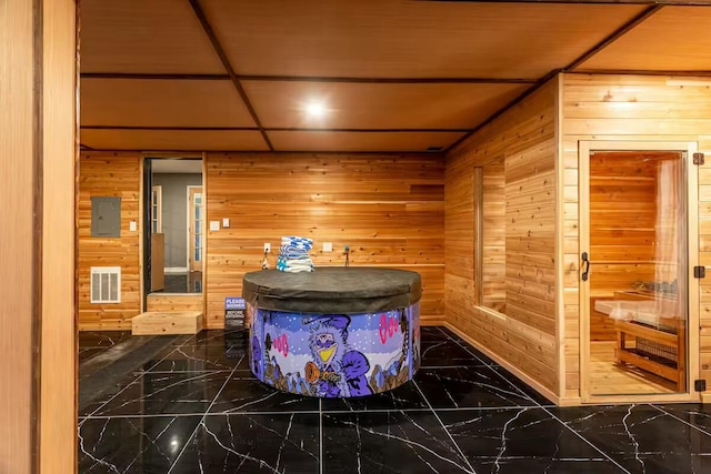 bathroom with visible vents, wood walls, and marble finish floor