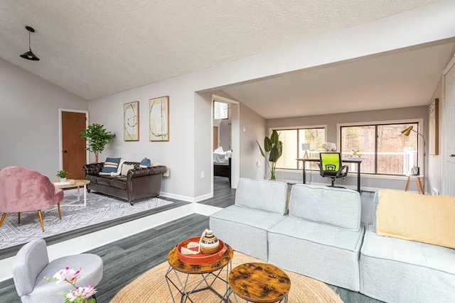 living area with lofted ceiling, wood finished floors, baseboards, and a textured ceiling