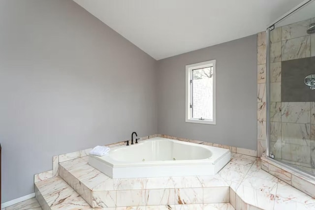 full bath with baseboards, lofted ceiling, a tub with jets, and a stall shower