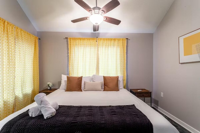 bedroom with baseboards, lofted ceiling, and a ceiling fan