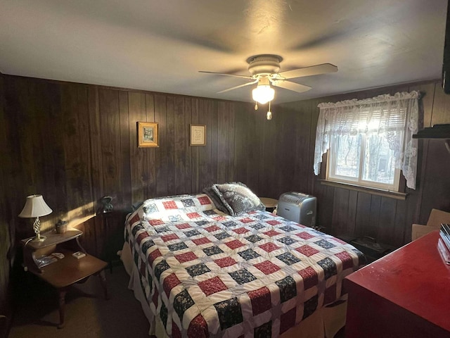 bedroom with wooden walls and a ceiling fan