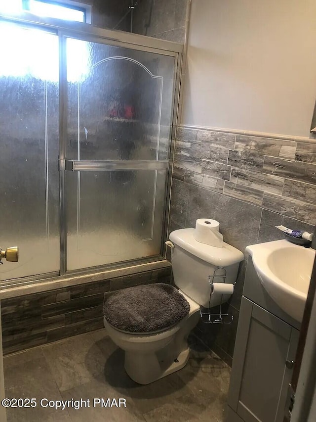 full bathroom featuring vanity, toilet, shower / bath combination with glass door, and tile walls