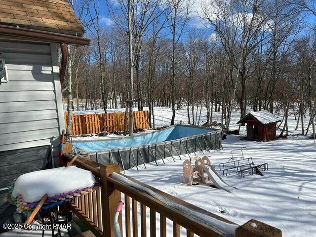 snow covered deck with a covered pool