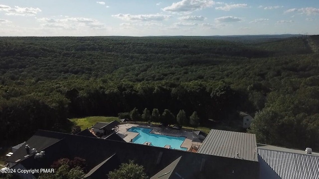 bird's eye view of a heavily wooded area and a pool area