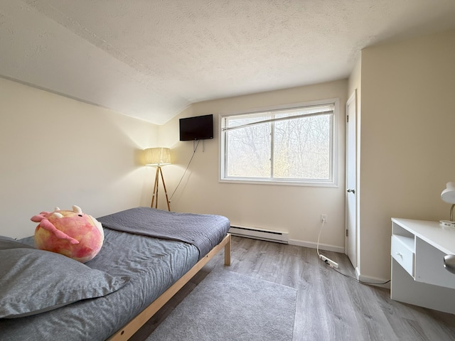 bedroom featuring baseboard heating, wood finished floors, a textured ceiling, lofted ceiling, and baseboards
