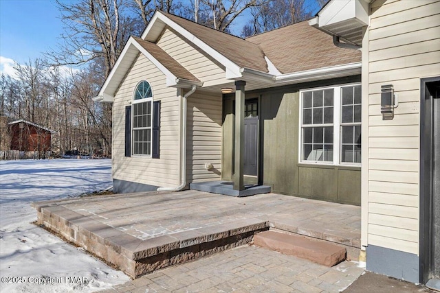 property entrance featuring a shingled roof