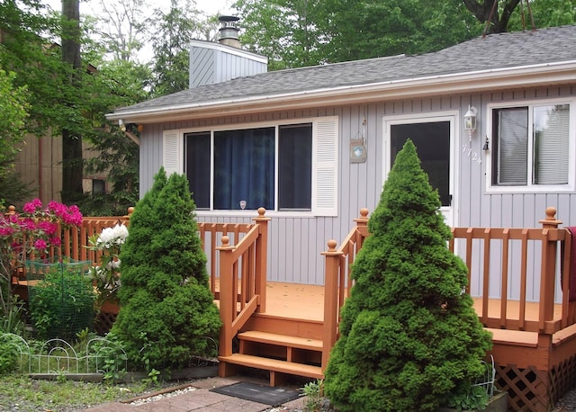 7724 Apple Ln, Tobyhanna, PA 18466 - view of exterior entry featuring roof with shingles, a wooden deck, and a chimney