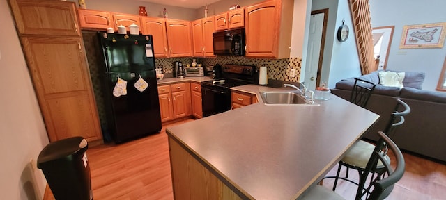 25 Byron Ln, Albrightsville, PA 18210 - kitchen featuring black appliances, a sink, a peninsula, light wood-style floors, and decorative backsplash