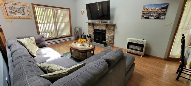 25 Byron Ln, Albrightsville, PA 18210 - living area with heating unit, wood finished floors, baseboard heating, a stone fireplace, and baseboards