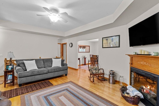250 Grouse Run, Cresco, PA 18326 - living area featuring a warm lit fireplace, wood finished floors, a ceiling fan, and baseboards