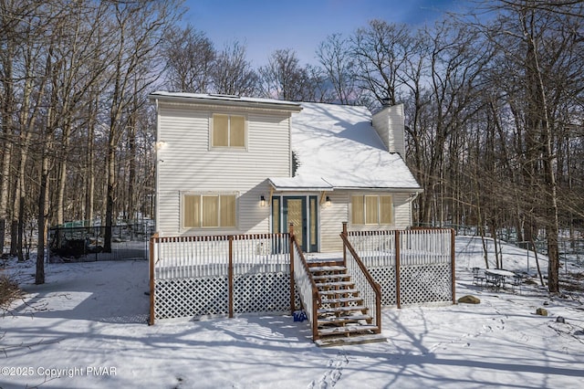 view of front of house with stairway, a chimney, and a wooden deck