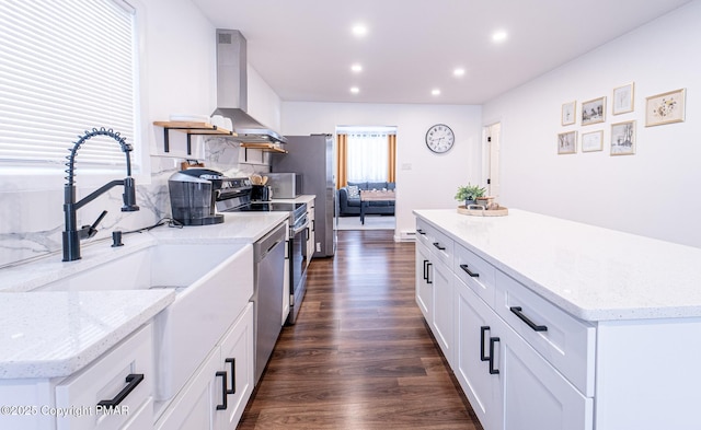 kitchen with dark wood-style floors, range hood, stainless steel appliances, backsplash, and white cabinetry