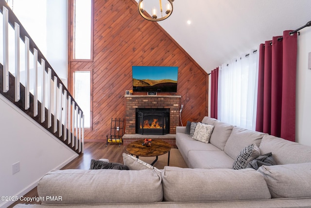 living area with wood walls, stairs, high vaulted ceiling, and wood finished floors