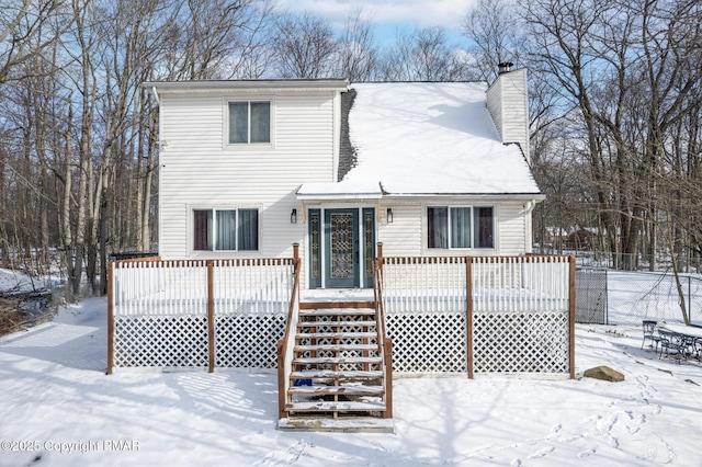 view of front facade with fence, a chimney, and a wooden deck