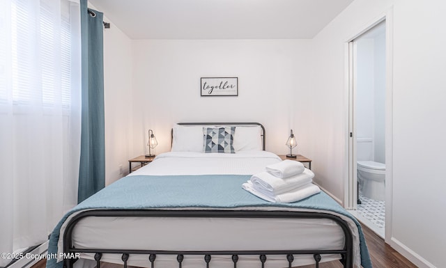 bedroom with baseboards, ensuite bathroom, and wood finished floors