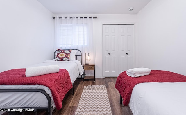 bedroom featuring a closet and dark wood-style flooring