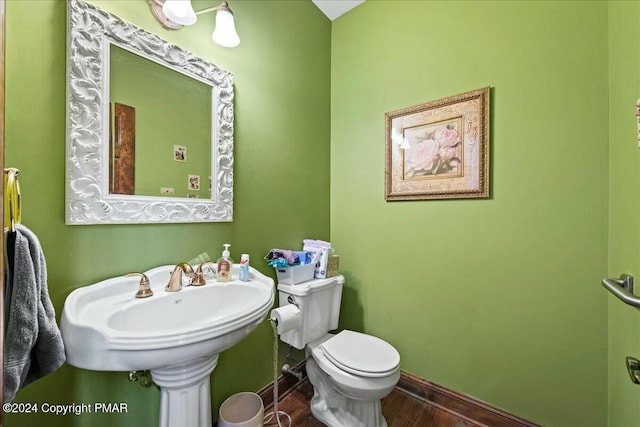 bathroom featuring toilet, baseboards, and wood finished floors