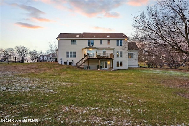 back of house featuring stairway, a lawn, and a deck