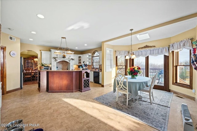 kitchen with arched walkways, black dishwasher, recessed lighting, visible vents, and an inviting chandelier