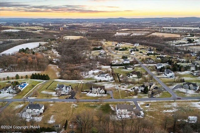 aerial view at dusk featuring a mountain view