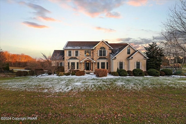 traditional-style house with stone siding and stucco siding