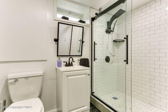 full bathroom with toilet, a shower stall, and vanity