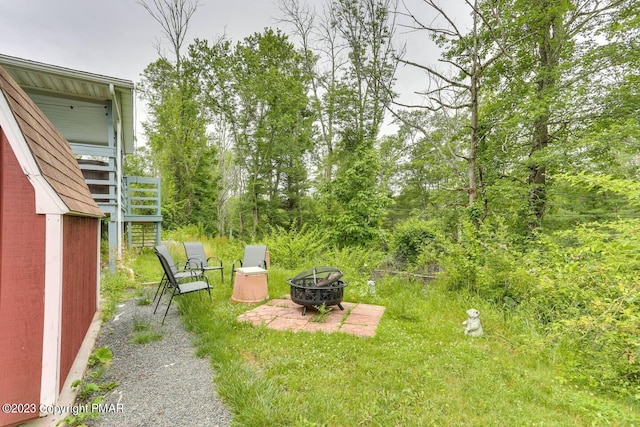 view of yard featuring stairs and a fire pit