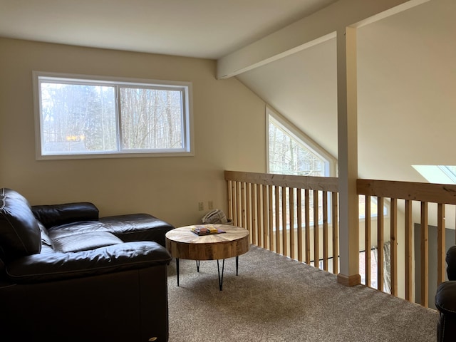 living area with a wealth of natural light, carpet flooring, and lofted ceiling with beams