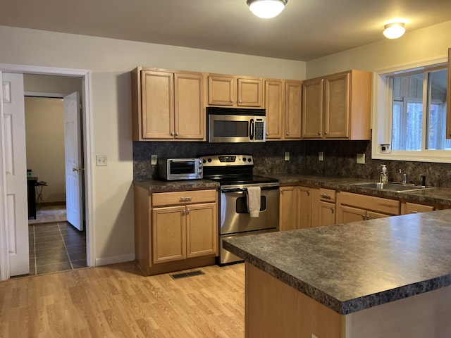 kitchen with dark countertops, stainless steel appliances, and a sink