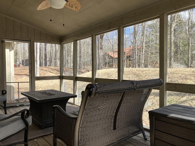 sunroom with lofted ceiling and a ceiling fan