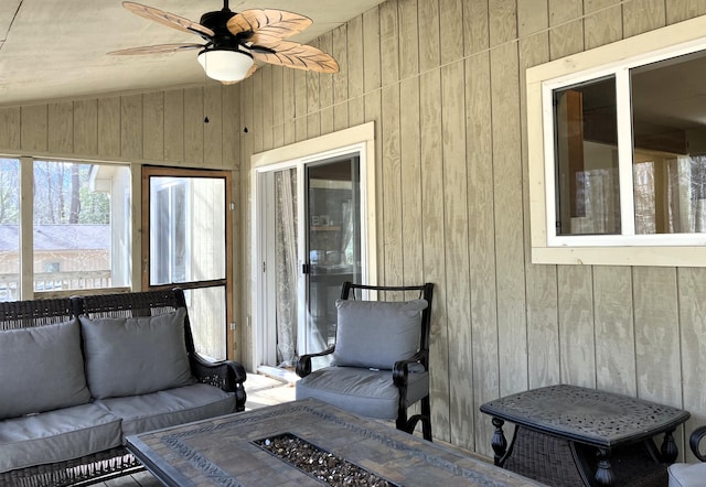 sunroom featuring lofted ceiling and a ceiling fan