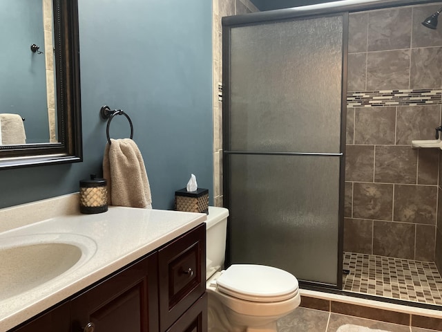 full bath featuring toilet, a shower stall, and vanity