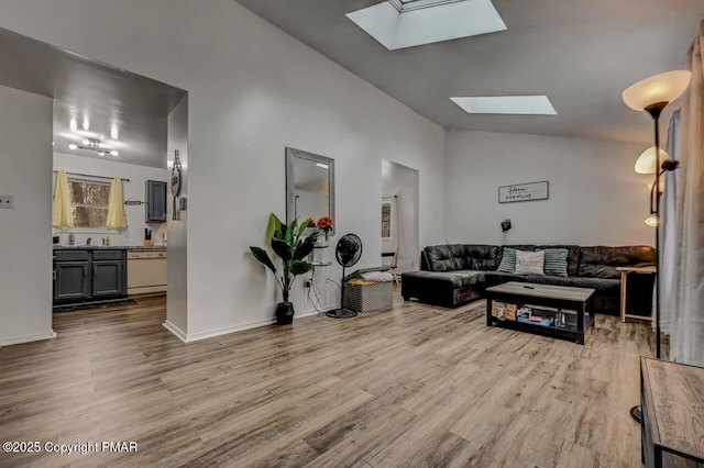 living room featuring lofted ceiling with skylight and light wood-type flooring