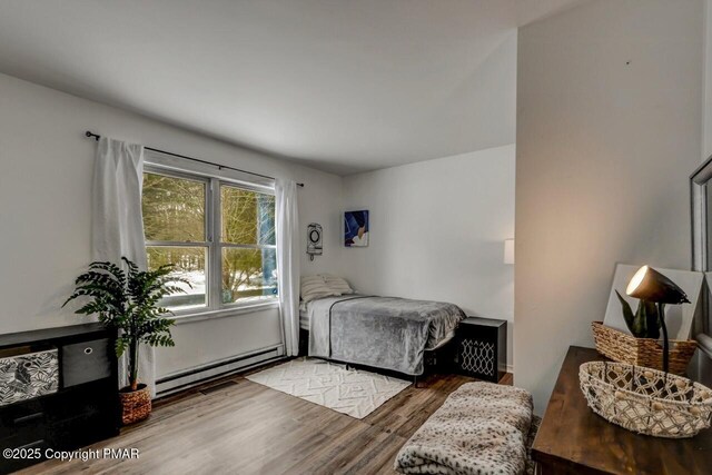 bedroom featuring hardwood / wood-style flooring and a baseboard radiator