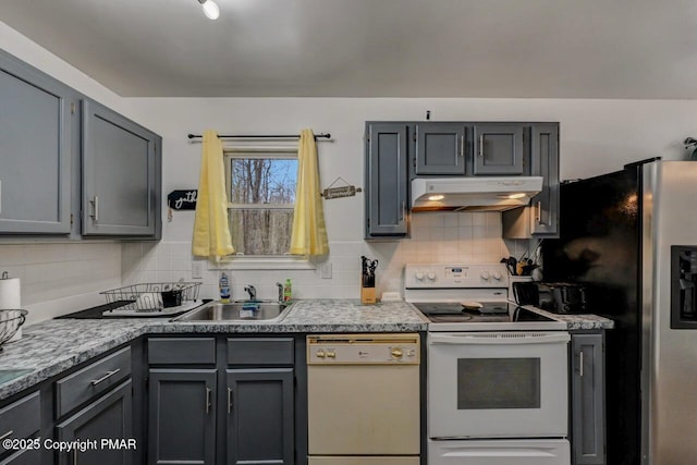 kitchen with tasteful backsplash, white appliances, sink, and gray cabinetry