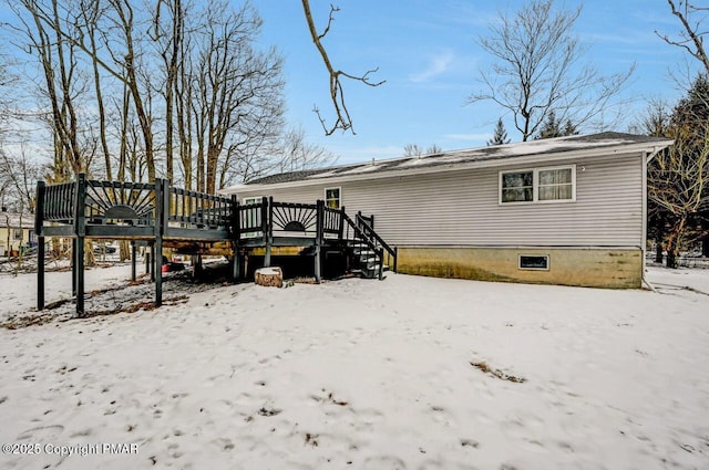 snow covered house featuring a deck